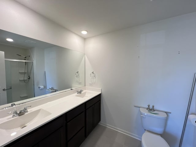 bathroom featuring a sink, a shower with shower door, toilet, and double vanity