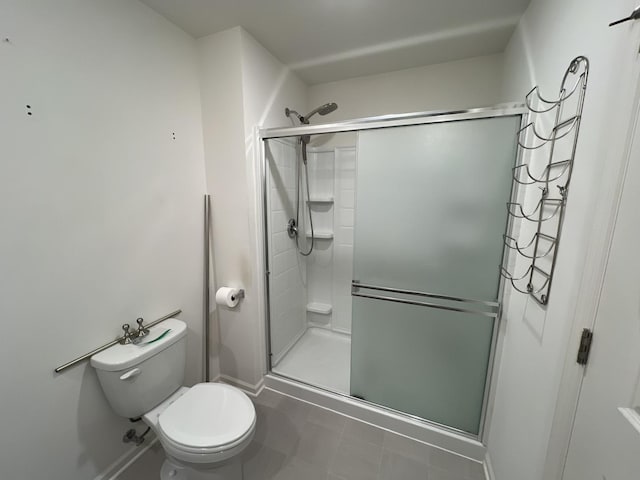 full bath featuring a shower stall, toilet, and baseboards