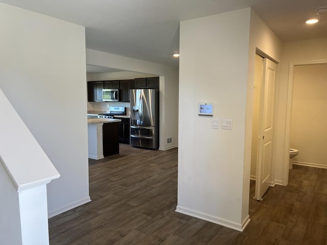 hall featuring recessed lighting, visible vents, baseboards, and dark wood-style flooring