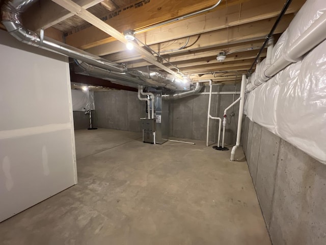 unfinished basement featuring heating unit