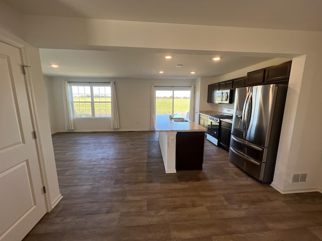 kitchen featuring visible vents, baseboards, dark wood-type flooring, and appliances with stainless steel finishes