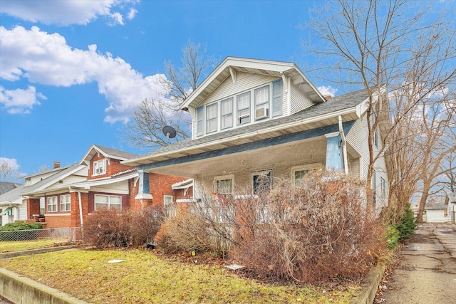 view of front of home featuring brick siding, a front lawn, and fence