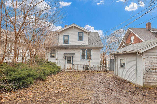 rear view of property featuring roof with shingles