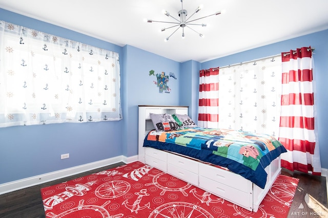 bedroom featuring a chandelier, wood finished floors, and baseboards