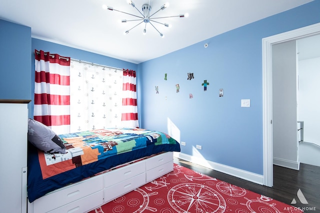 bedroom with baseboards, a chandelier, and wood finished floors