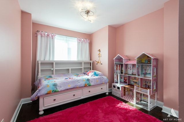 bedroom featuring wood finished floors and baseboards