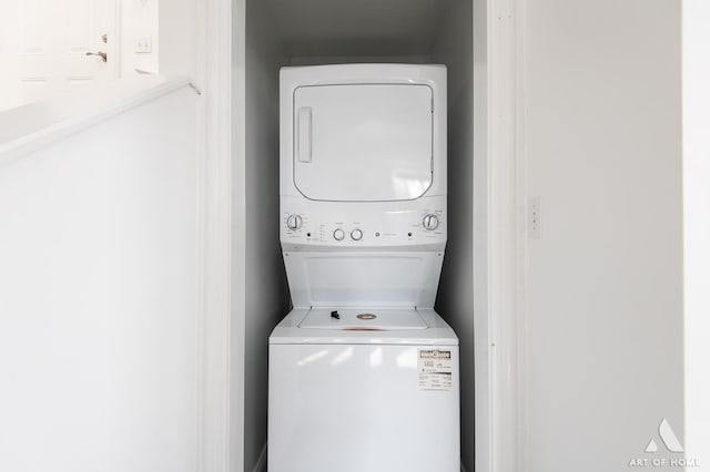 clothes washing area featuring stacked washer / drying machine and laundry area