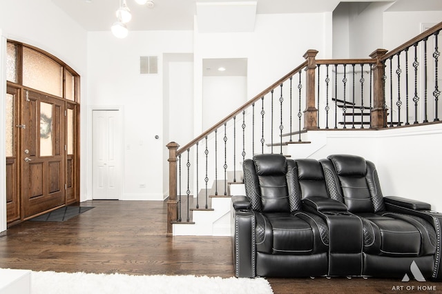 foyer entrance featuring visible vents, a high ceiling, wood finished floors, baseboards, and stairs