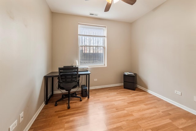 office featuring light wood-type flooring, visible vents, ceiling fan, and baseboards