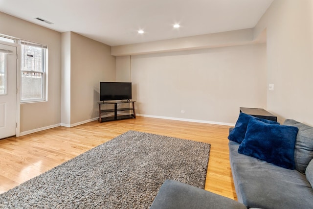 living area with baseboards, visible vents, wood finished floors, and recessed lighting