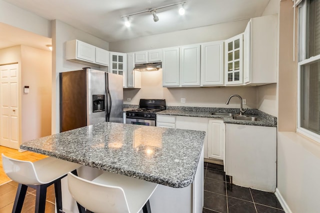 kitchen with stainless steel appliances, a sink, white cabinetry, and under cabinet range hood