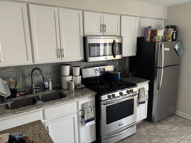 kitchen with stainless steel appliances, white cabinets, and a sink