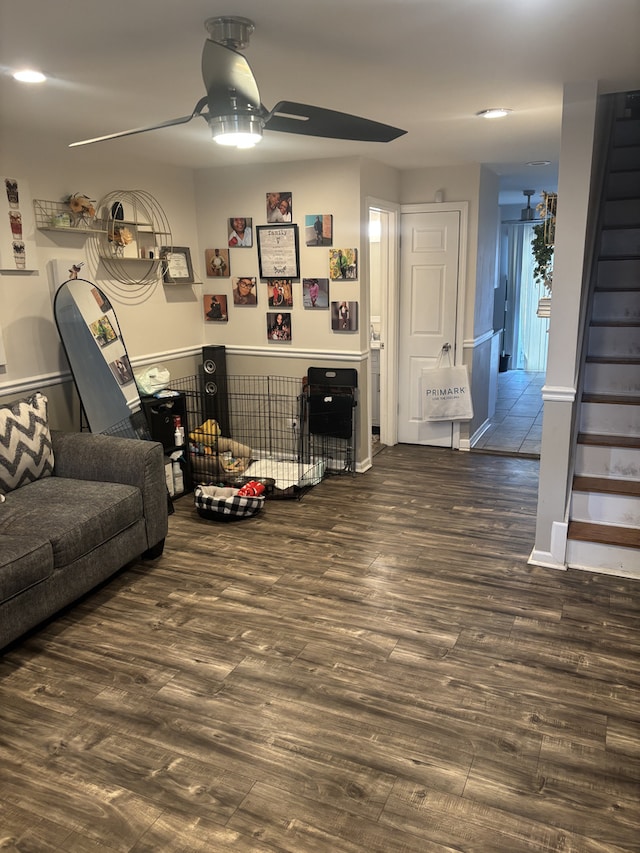 living area with ceiling fan, stairway, and wood finished floors