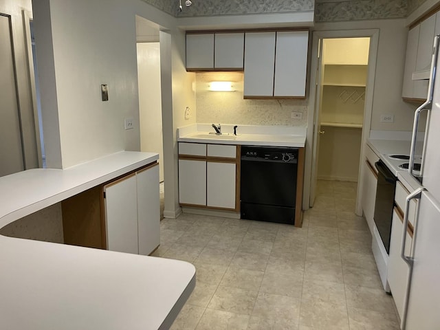 kitchen featuring light tile patterned floors, black dishwasher, light countertops, a sink, and range with electric stovetop