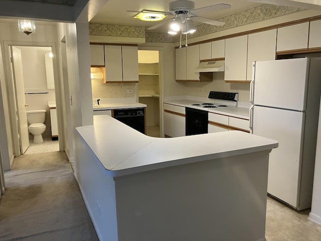 kitchen with under cabinet range hood, black dishwasher, electric stove, light countertops, and freestanding refrigerator