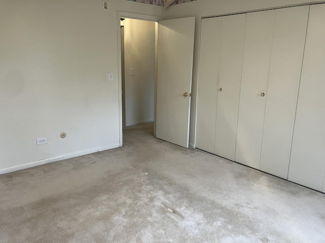 unfurnished bedroom with a closet and baseboards