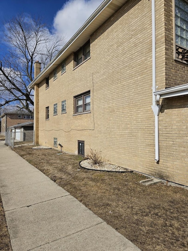 view of home's exterior featuring brick siding and a chimney