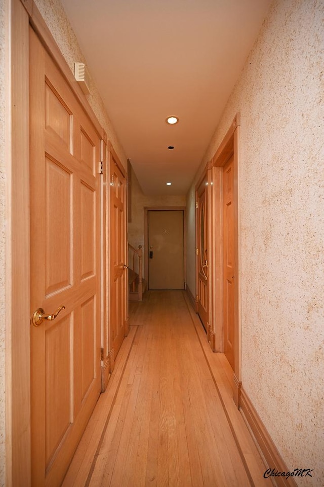 corridor featuring light wood-style flooring and recessed lighting