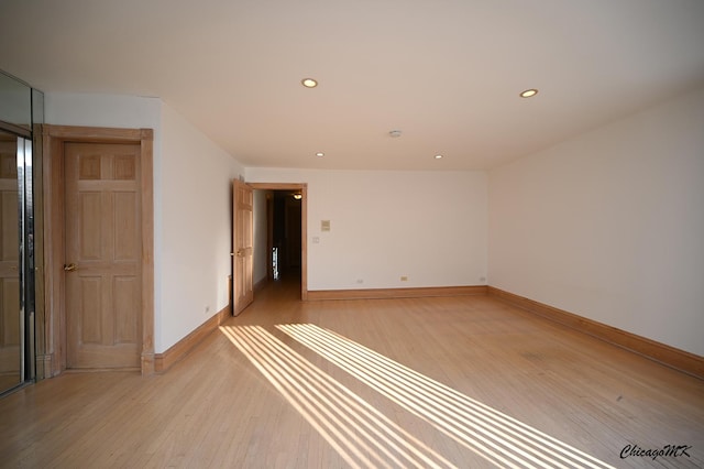 unfurnished room with light wood-type flooring, baseboards, and recessed lighting