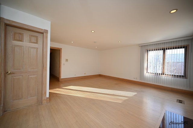 empty room featuring light wood-style flooring, recessed lighting, visible vents, and baseboards