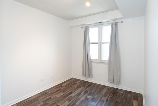 empty room featuring dark wood finished floors and baseboards