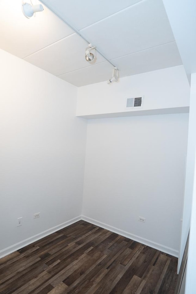 unfurnished room featuring dark wood-style floors, baseboards, and visible vents