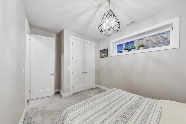 carpeted bedroom featuring a closet, visible vents, and baseboards