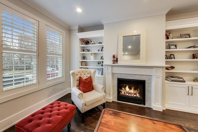 sitting room with baseboards, built in features, a premium fireplace, dark wood-style flooring, and recessed lighting