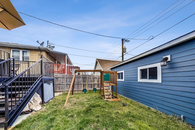 view of yard featuring a deck, fence, and stairway