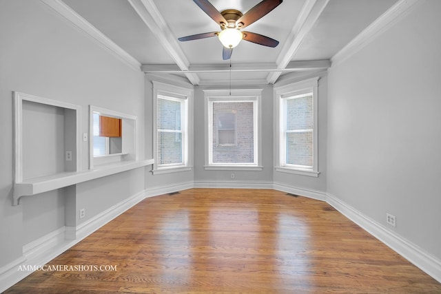 empty room with baseboards, coffered ceiling, wood finished floors, crown molding, and beam ceiling