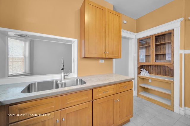 kitchen with light countertops, a sink, and light tile patterned floors