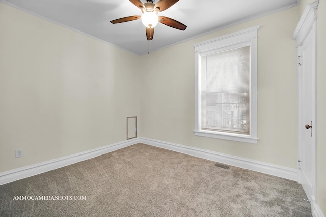 carpeted spare room with ornamental molding, visible vents, ceiling fan, and baseboards