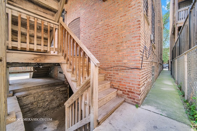 property entrance with brick siding and fence