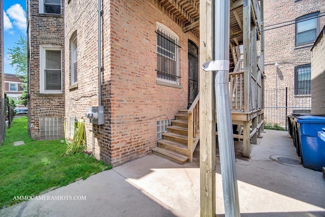 view of exterior entry with a yard and brick siding