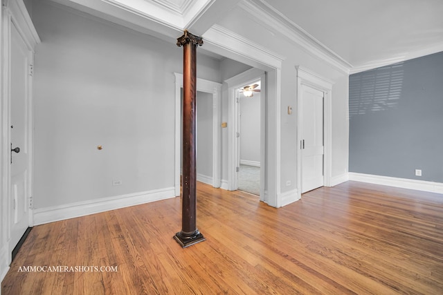 interior space with crown molding, baseboards, and wood finished floors