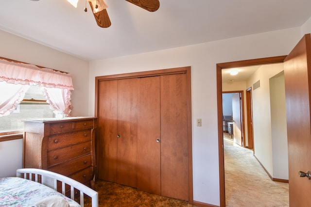 carpeted bedroom with baseboards, a closet, visible vents, and a ceiling fan