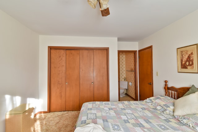 carpeted bedroom featuring ensuite bath and a ceiling fan