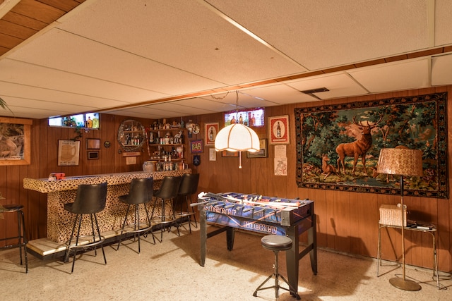 bar featuring a paneled ceiling, visible vents, wood walls, and a dry bar