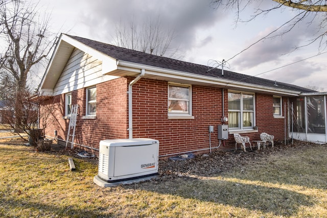 view of side of home featuring a yard, a shingled roof, and brick siding