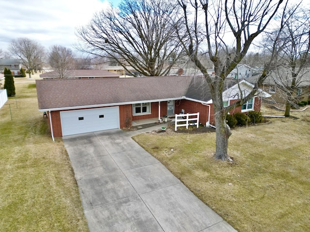 ranch-style house with a garage, concrete driveway, brick siding, and a front yard