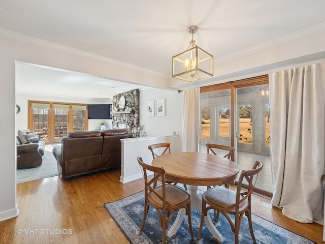 dining area featuring a notable chandelier, wood finished floors, and crown molding