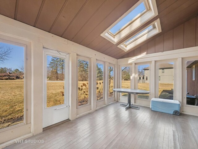 unfurnished sunroom featuring lofted ceiling with skylight and plenty of natural light