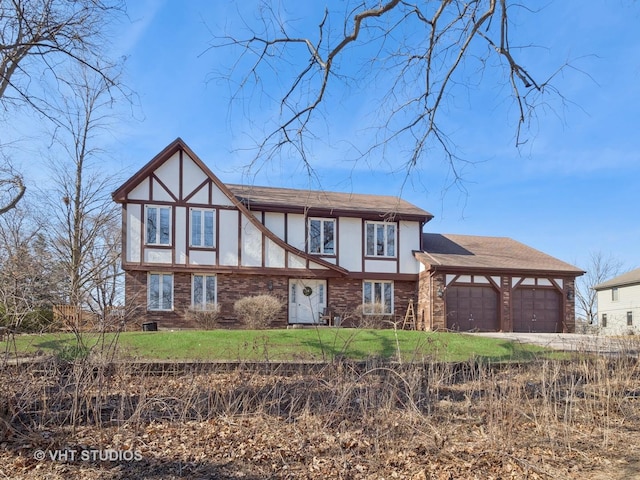 english style home featuring a front yard, brick siding, a garage, and stucco siding