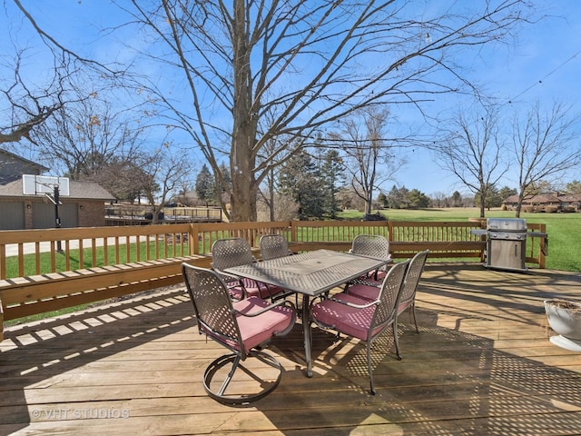 wooden terrace featuring grilling area, a lawn, and outdoor dining space