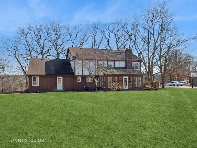 back of property featuring a yard and a chimney