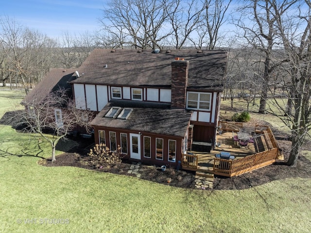 back of house featuring a shingled roof, a lawn, stucco siding, a chimney, and a deck