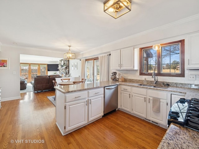 kitchen featuring dishwasher, a peninsula, white cabinets, and a sink