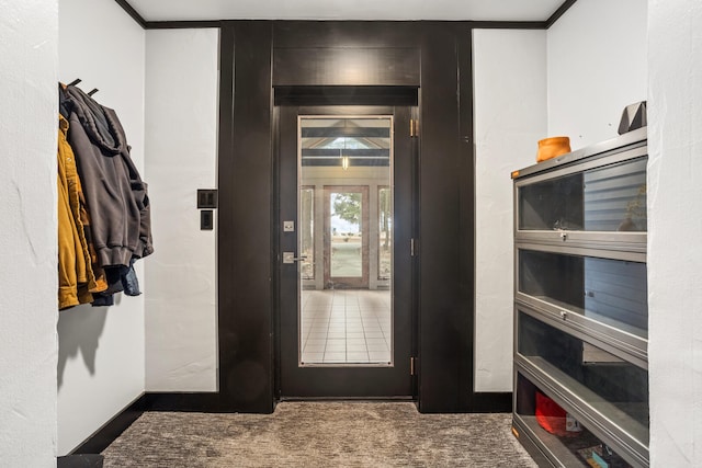 entrance foyer with carpet, baseboards, and ornamental molding