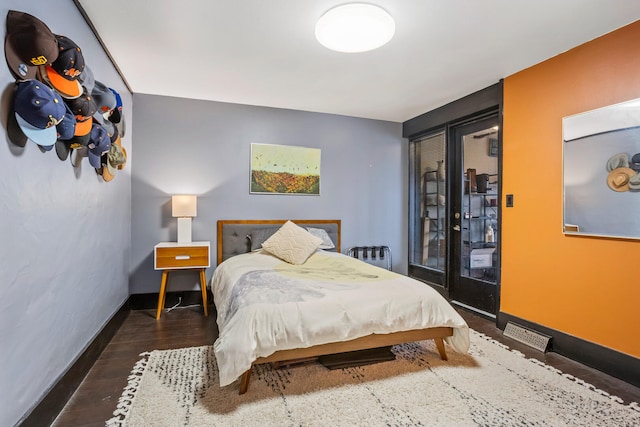 bedroom featuring baseboards, wood finished floors, and access to outside