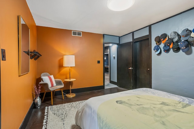 bedroom featuring visible vents, baseboards, and wood finished floors